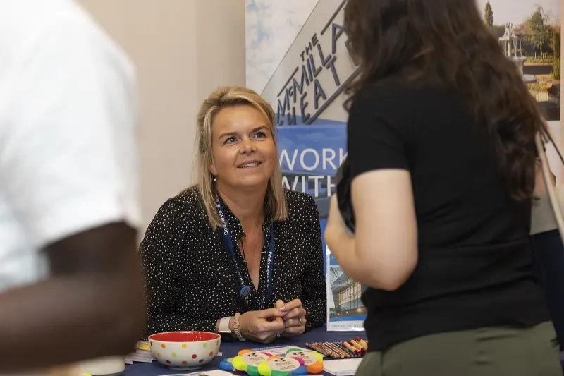 Lady chatting to a job hunter at a jobs fair